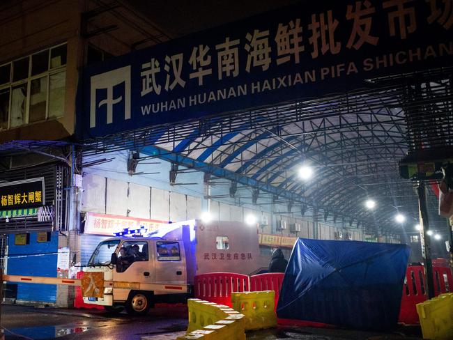 (FILES) In this file photograph taken on January 11, 2020, members of staff of the Wuhan Hygiene Emergency Response Team drive their vehicle as they leave the closed Huanan Seafood Wholesale Market in the city of Wuhan, in Hubei, Province, where the Wuhan health commission said that the man who died from a respiratory illness had purchased goods. - A second person has died in China from a mystery virus that has stricken dozens and appeared in two other Asian countries, officials said. (Photo by NOEL CELIS / AFP)