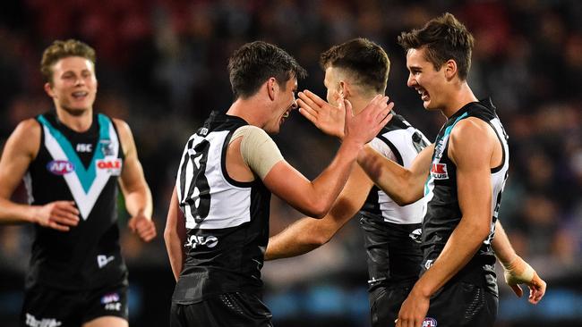 Xavier Duursma runs in to celebrate a goal with Zak Butters, Robbie Gray and Connor Rozee on Friday. Picture: Daniel Kalisz/Getty Images