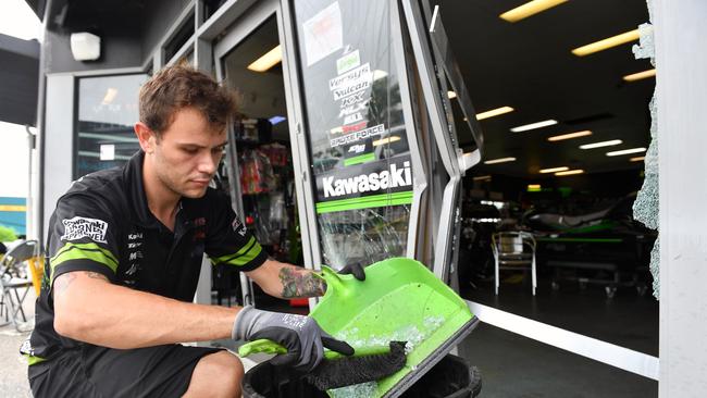 Mackay Kawasaki mechanic Jack Burgess cleans up the shop front after a break in. Picture: Tony Martin