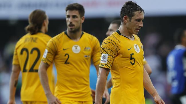 Socceroos skipper Mark Milligan leaves the pitch with dejected teammates. Picture:  AP.