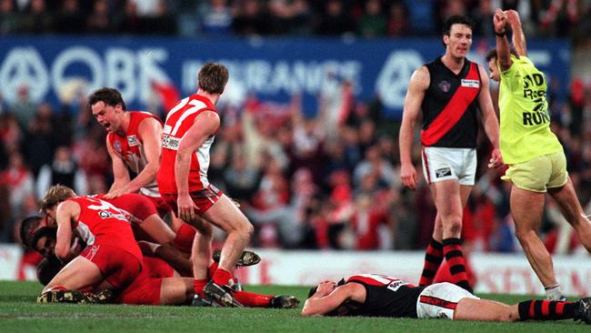 Agony and ecstasy. Swans players swamp Tony Lockett, heartbreak for Steven Alessio.