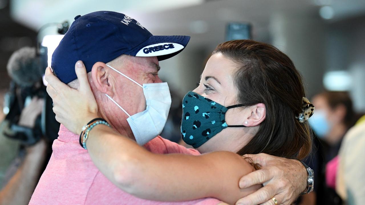 Paul Gimpel hugs daughter Rebecca Underhill after she arrived on the first flight from Sydney into Brisbane after border restrictions eased. Picture: Getty Images