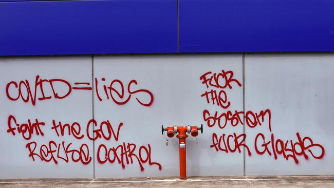 Anti-government and anti-Covid graffiti on a building opposite the fire scene. Picture: NCA NewsWire / Flavio Brancaleone