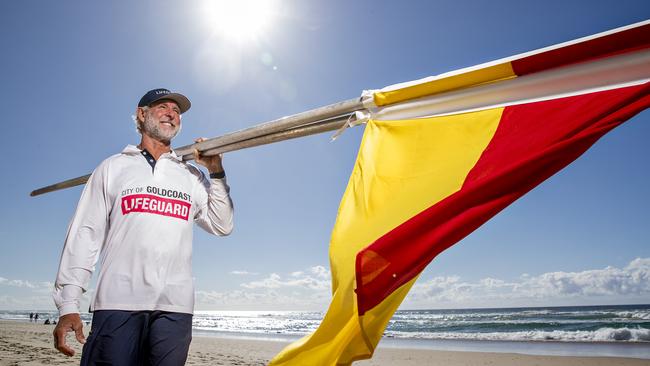 Senior City of Gold Coast lifeguard Rob Dorrough setting up the red and yellow flags at Surfers Paradise. Picture: Jerad Williams