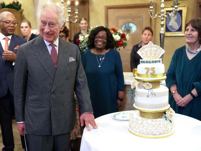 King Charles III reacts while holding a knife as he prepares to cut a birthday cake as he attends his 75th birthday party. Picture: AFP