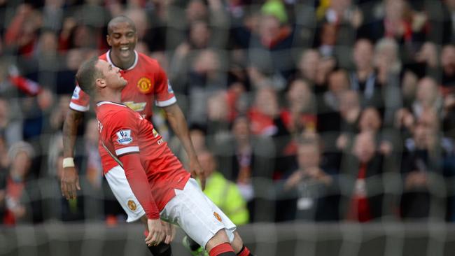 Manchester United's English striker Wayne Rooney celebrates with a topical celebration after scoring their third goal during the English Premier League football match between Manchester United and Tottenham Hotspur at Old Trafford in Manchester, north west England, on March 15, 2015. Manchester United star Wayne Rooney has found himself embroiled in a bizarre incident after footage emerged of him being knocked out by former team-mate Phil Bardsley in an impromptu boxing match in his kitchen. Rooney was sent sprawling in his home after Bardsley caught him with a left jab as they indulged in a friendly sparring bout. AFP PHOTO / OLI SCARFF RESTRICTED TO EDITORIAL USE. NO USE WITH UNAUTHORIZED AUDIO, VIDEO, DATA, FIXTURE LISTS, CLUB/LEAGUE LOGOS OR “LIVE” SERVICES. ONLINE IN-MATCH USE LIMITED TO 45 IMAGES, NO VIDEO EMULATION. NO USE IN BETTING, GAMES OR SINGLE CLUB/LEAGUE/PLAYER PUBLICATIONS.