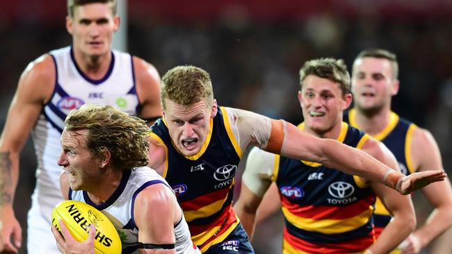 Reilly O’Brien in hot pursuit of Fremantle’s David Mundy. Picture: Mark Brake/Getty Images