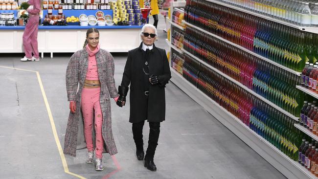 Lagerfeld strutting the Chanel supermarket catwalk with model Cara Delevingne in 2014. Picture: Patrick Kovarik/AFP