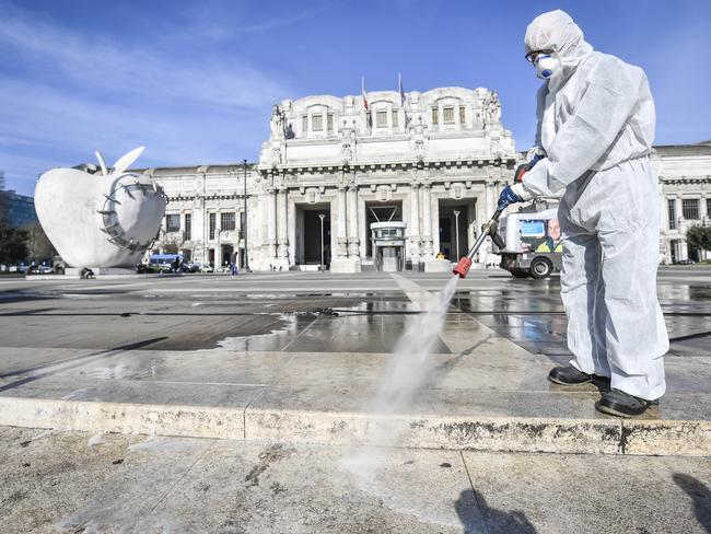 A worker wearing a protective suit disinfects the area in front of the Centrale main railway station, in Milan. Picture: AP