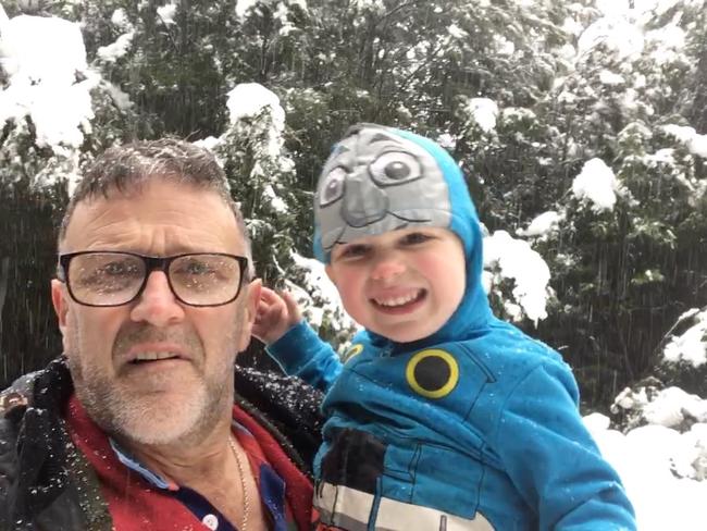 Wojt Kowaluk, of Glen Huon, and his son Reuben, 2, take in the snow on the road to Hartz Peak. Picture WOJT KOWALUK