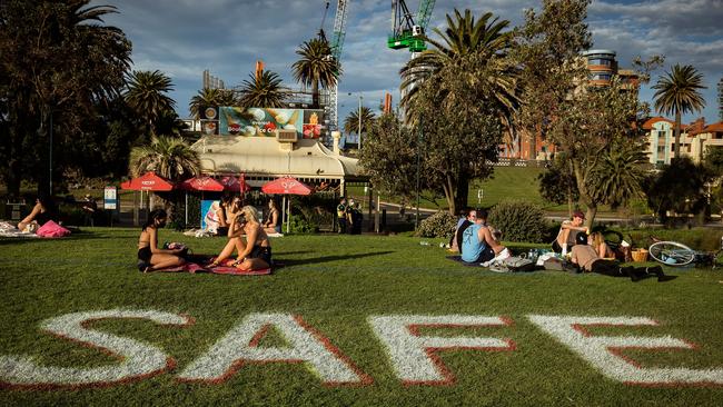 People enjoy the sun at St Kilda beach while social distancing. Pictures: Getty