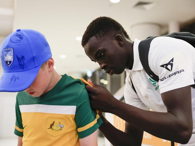 SYDNEY, AUSTRALIA - DECEMBER 05: Garang Kuol of the Socceroos signs autographs on arrival at Sydney International Airport on December 05, 2022 in Sydney, Australia. (Photo by Mark Evans/Getty Images)