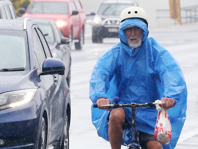 Showers and rain has finally arrived in Cairns and the Far North, affecting all coastal areas. A man rides his bike alongside the traffic on Mulgrave Road in the wet weather. Picture: Brendan Radke