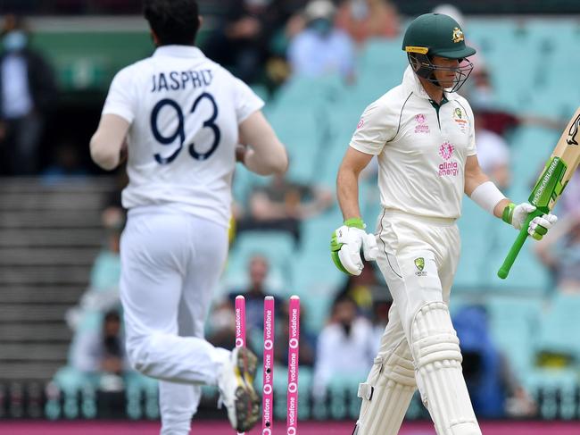 Australian captain Tim Paine (R) is clean bowled by Indian paceman Jasprit Bumrah (L) on day two of the third cricket Test match at Sydney Cricket Ground (SCG) between Australia and India on January 8, 2021. (Photo by Saeed KHAN / AFP) / --IMAGE RESTRICTED TO EDITORIAL USE - NO COMMERCIAL USE--