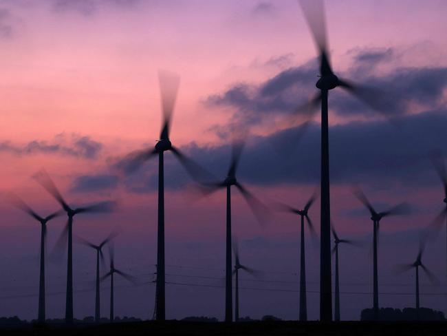 Wind turbines are seen at a wind farm at sunset in Schuelp near St Peter-Ording, northern Germany, on September 19, 2024. (Photo by Daniel ROLAND / AFP)