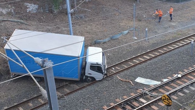 Truck going onto train tracks near Manly Station.