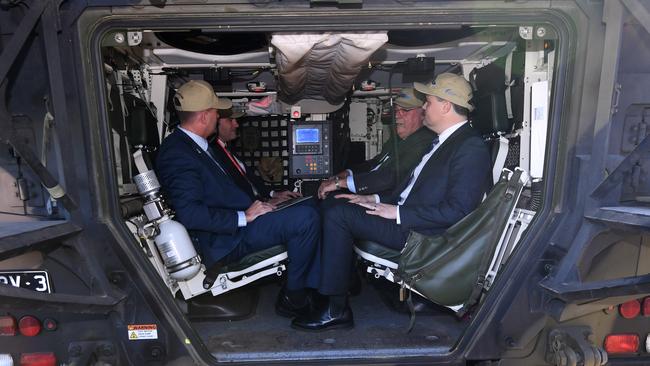 Queensland MPs and Senators sit inside a Rheinmetall Boxer CRV outside Parliament House.