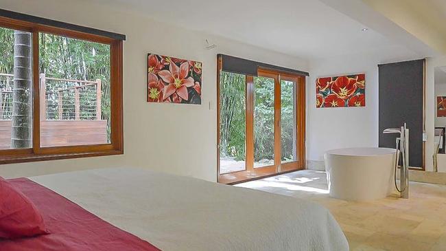 One of the bedrooms features an open bath with leafy views.