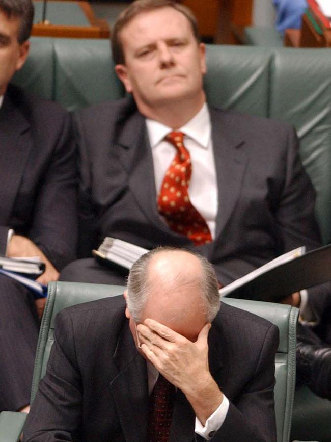 Prime Minister John Howard (front) holds his head in his hand as Peter Costello watches on during Question Time in 2002. Picture: File