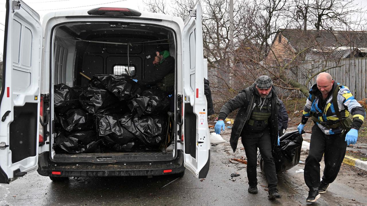 Communal workers carry a body of a civilian man in the town of Bucha, not far from the Ukrainian capital of Kyiv on April 3. Picture: Sergei SUPINSKY / AFP