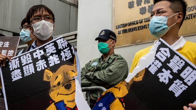 Pro-democracy activists tear a placard of Winnie the Pooh that represents Chinese President Xi Jinping during a protest against a proposed new security law outside the Chinese Liaison Office in Hong Kong. Picture: AFP