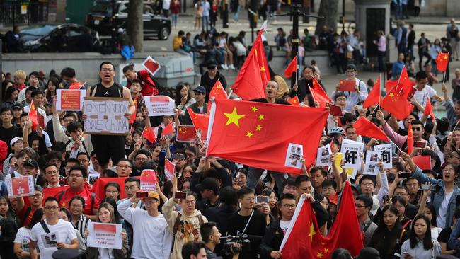 Counter-protesters hold up Chinese flags to oppose pro-democracy demonstrators gathering in central London. Picture: AFP