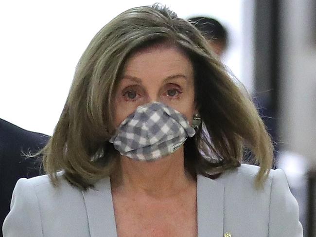 Nancy Pelosi tries on a mask. Picture: AFP