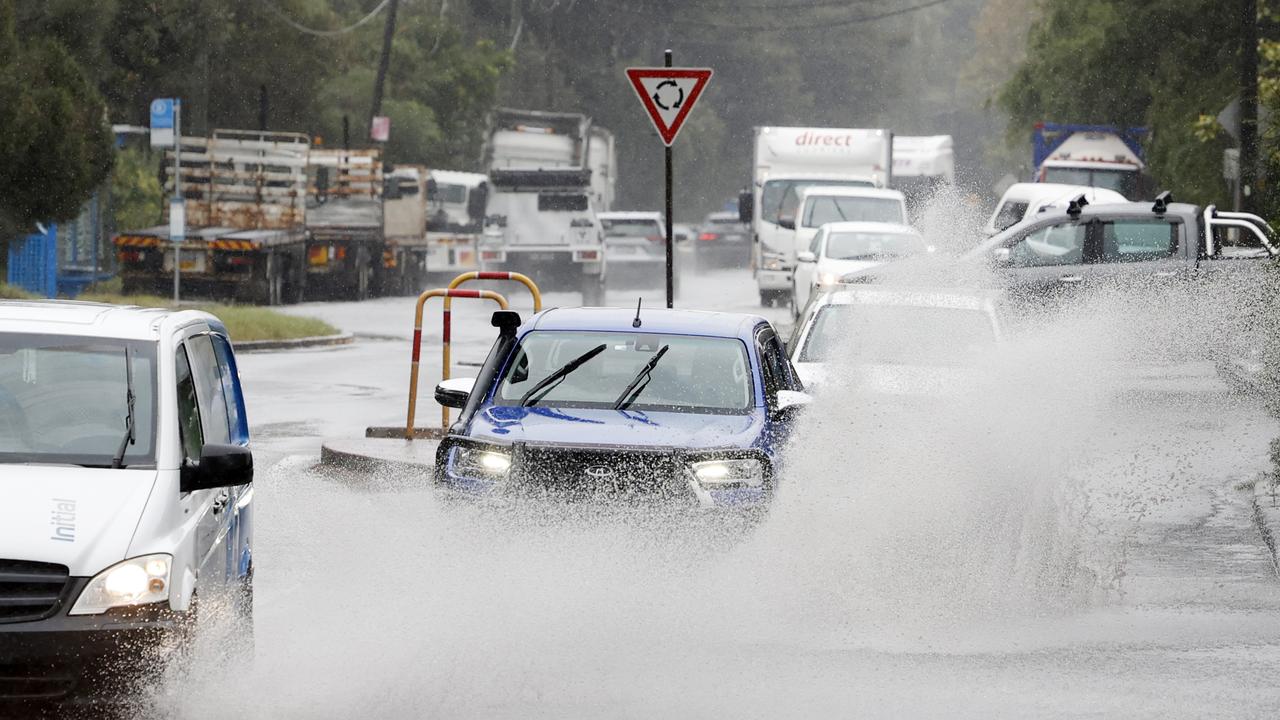 Traffic passing through water on Botany Road at Port Botany as constant rain falls across Sydney. Picture: Richard Dobson