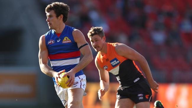 Bulldogs star Josh Dunkley breaks away from Giant Harry Perryman during the Round 22 victory in Sydney. Picture: Mark Metcalfe/Getty