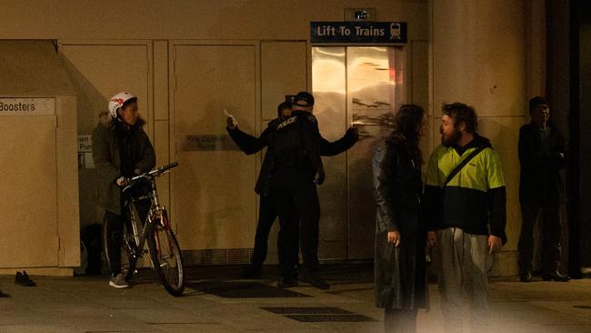 Police are seen interacting with a man along North Terrace at night. The Advertiser: Morgan Sette