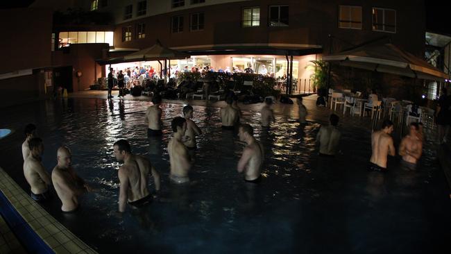 At midnight, players do recovery in the hotel pool as fans celebrate the win over Port Adelaide in the bar.