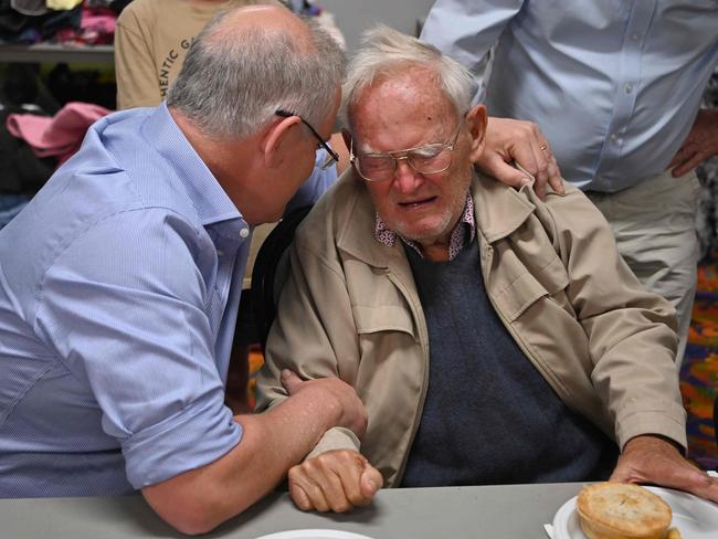 Prime Minister Scott Morrison comforts Owen Whalan, 85, at an evacuation centre in Taree. Picture: AAP/Peter P