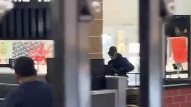 Screenshot from supplied video of an armed bandit, which police allege was Paul Flanagan, running from the jewellery store in the Carnes Hill Plaza.