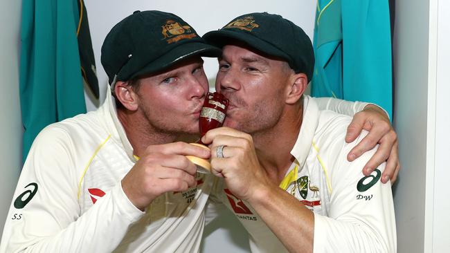 Australian captain Steve Smith (left) and opener David Warner celebrate with the Ashes urn in the team dressing rooms on Monday evening.