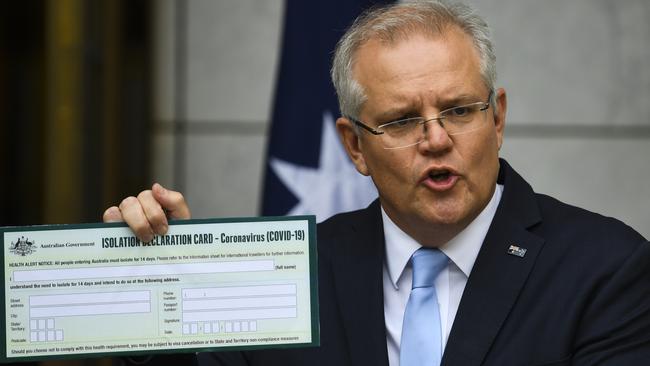 Australian Prime Minister Scott Morrison holds up a coronavirus Isolation Declaration Card as he speaks to the media during a press conference at Parliament House in Canberra. Picture: AAP