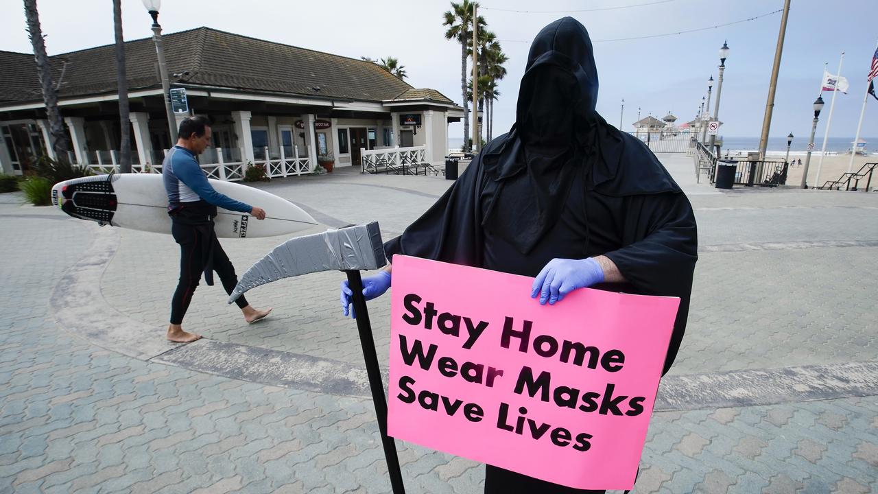 Spencer Kelly, dressed as the grim reaper, demonstrated in favour of the stay-at-home order during the coronavirus pandemic at the pier in Huntington Beach, California. Picture: AP Photo/Chris Carlson, File.