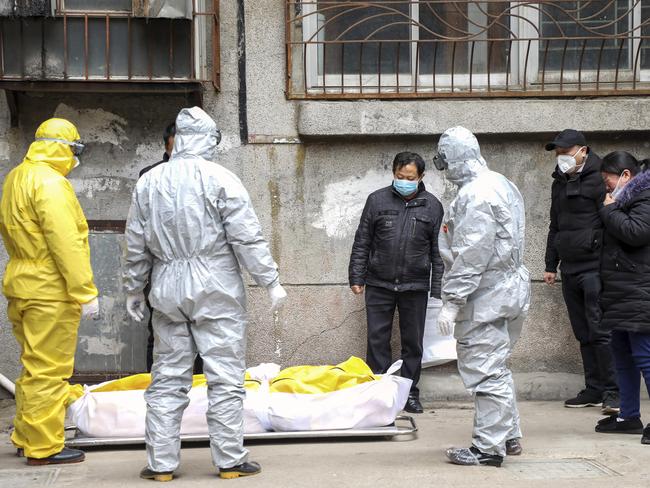 Funeral home workers in Wuhan remove the body of a person suspected to have died from the coronavirus outbreak. Picture: AP