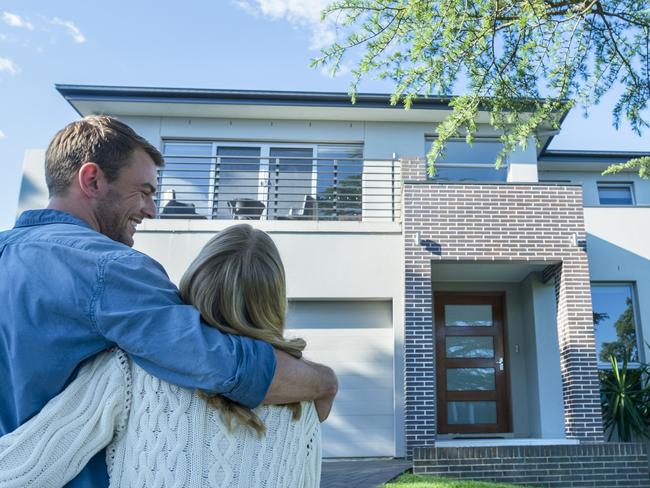 generic; couple in front of house for sale; house sold; real estate; hugging; iSTOCK