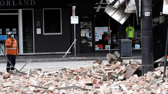 A worker examines the damage to a building in Chapel Street in Melbourne after a 5.9 magnitude earthquake. Picture: William West/AFP