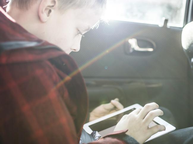 Generic image of a boy in a car with an iPad. Photo from Shutterstock.