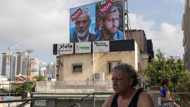 A billboard in Tel Aviv shows the word ‘eliminated’ in Hebrew over pictures of Hamas leaders Mohammed Deif and Ismail Haniyeh. Picture: Oren Ziv/AFP/Getty Images