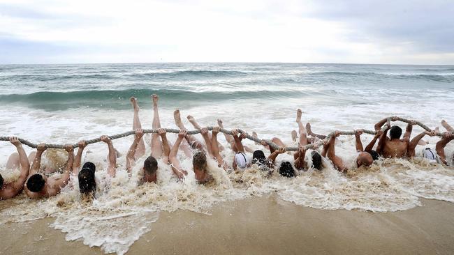 Port Adelaide players endure team sit-ups on the shoreline in Maroochydore. Picture: Sarah Reed.