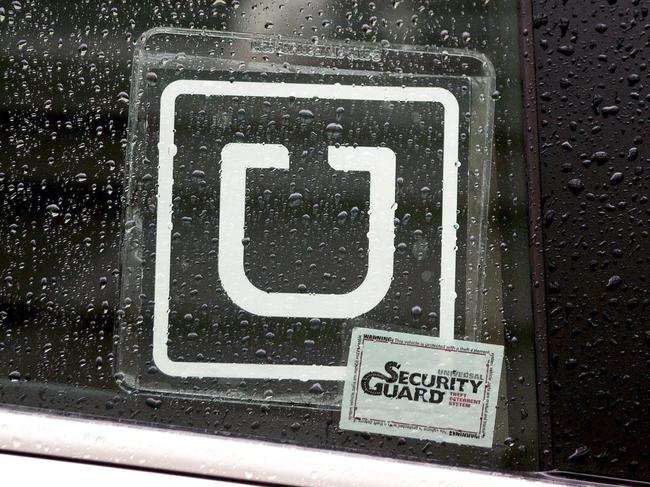 The Uber Technologies Inc. logo is displayed on the window of a vehicle after dropping off a passenger at Ronald Reagan National Airport (DCA) in Washington, D.C., U.S., on Wednesday, Nov. 26, 2014. Uber Technologies Inc. investors are betting the five-year-old car-booking app is more valuable than Twitter Inc. and Hertz Global Holdings Inc. Photographer: Andrew Harrer/Bloomberg