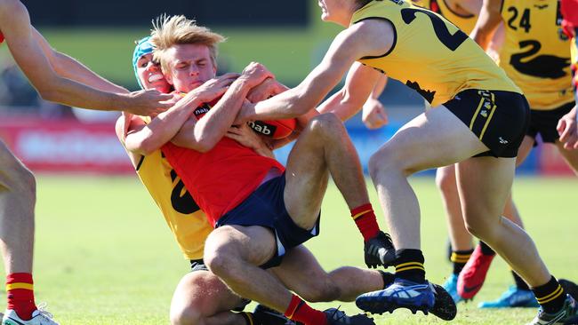 South Australia’s Jacob Kennerley is taken in a strong tackle by Luke English yesterday. Picture: Tait Schmaal