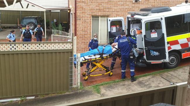 Mark Morgan (pictured on ambulance stretcher) is alleged to have deliberately run over his step father after dragging him outside onto a nature strip and kicking him in the face in Telopea. Picture: Supplied via NCA NewsWire