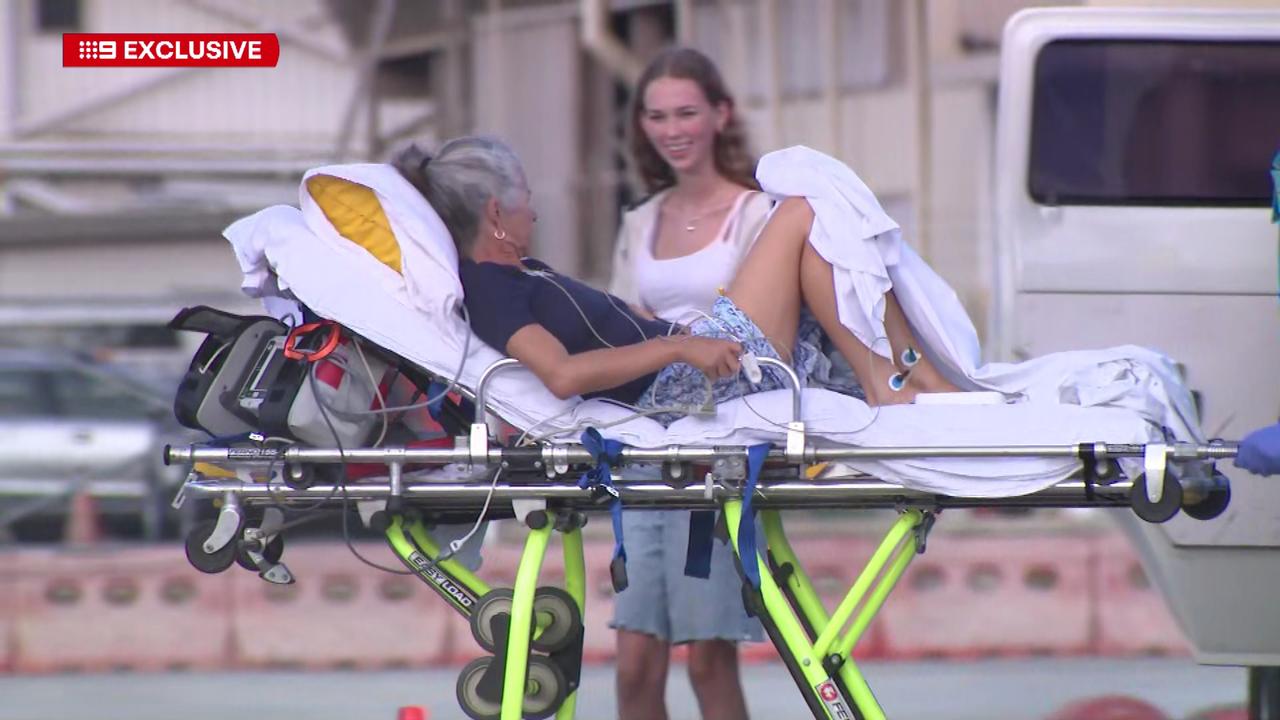 The final victim of the Fiji alcohol sickness is airlifted out of the country by medical staff as her daughter watches on. Picture: Nine News