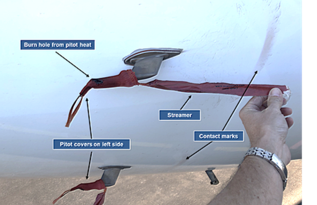 Reconstruction of pitot probe covers, showing damage and rub marks on aircraft skin from the streamer. Picture: ATSB