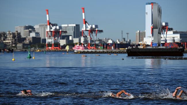 A capless Kai Edwards, left, with Tunisia's Oussama Mellouli and Portugal's Tiago Campos as the swim marathon unfolds. Picture: Oli Scarff/AFP