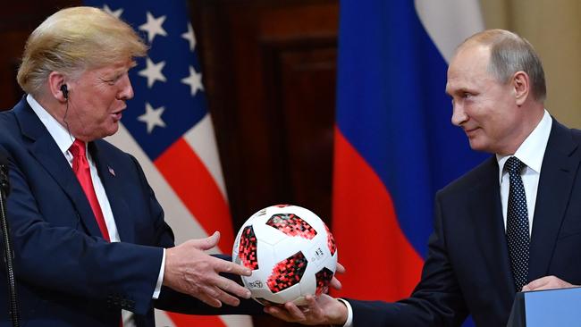 Russia's President Vladimir Putin (R) offers a ball of the 2018 football World Cup to US President Donald Trump during a joint press conference after their meeting.
