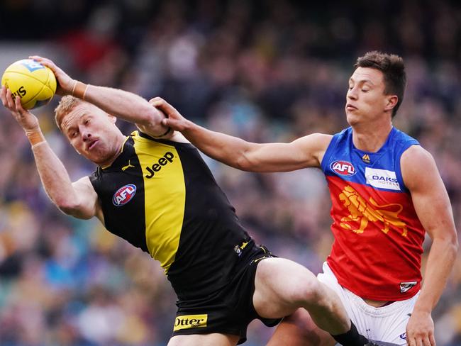 Nick Vlastuin of the Tigers marks the ball against Hugh McCluggage of the Lions during the Round 25 AFL match between the Richmond Tigers and the Brisbane Lions at the MCG in Melbourne, Sunday, August 25, 2019.  (AAP Image/Michael Dodge) NO ARCHIVING, EDITORIAL USE ONLY